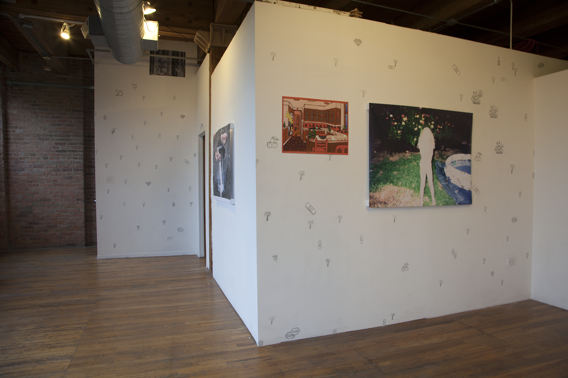 Installation view of three large scale prints hung on white walls with Kidpix graphics drawn in pencil on them